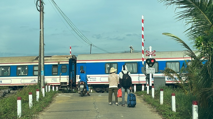 Người dân bất an khi chắn tàu tự động đã nâng lên thì tàu khách mới chạy đến, đoạn qua đường ngang thôn Hà Trung, xã Gio Châu, Gio Linh, Quảng Trị - Ảnh: HOÀNG TÁO