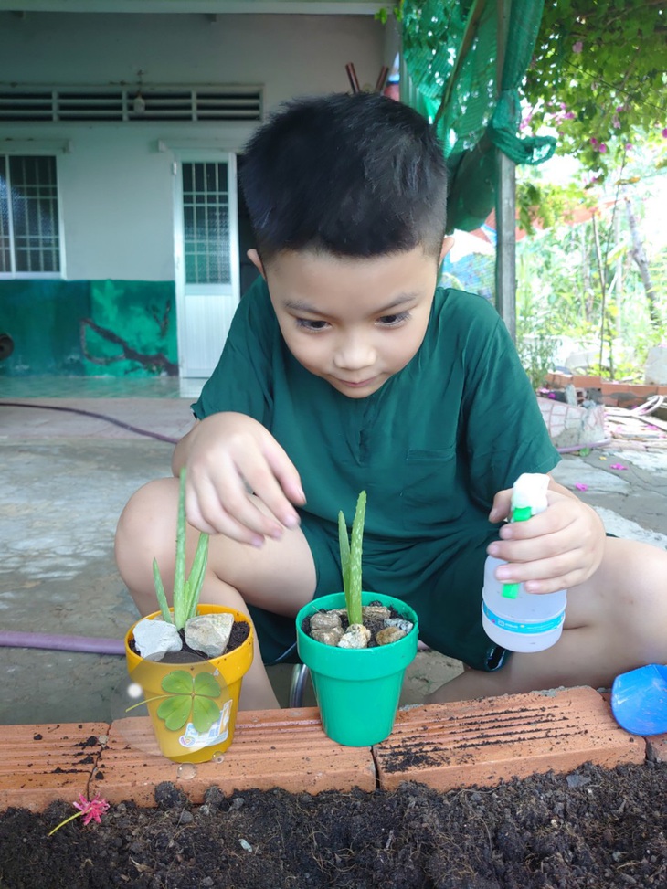 Con hào hứng chăm sóc chậu cây tự tay con trồng - Ảnh: CẨM GIANG