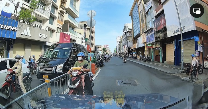 Hình ảnh người đàn ông chở theo em bé đi ngược chiều và quyết "thi gan" với tài xế ô tô - Ảnh chụp màn hình từ clip trên Facebook