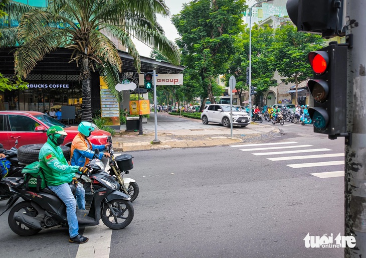 Người đi đường có thể quan sát thêm đèn tín hiệu giao thông vuông góc đường (thể hiện đèn xanh - đỏ ở hướng khác và thường có tín hiệu chớp trước khi chuyển đèn) để chủ động khởi động xe đi - Ảnh: CHÂU TUẤN