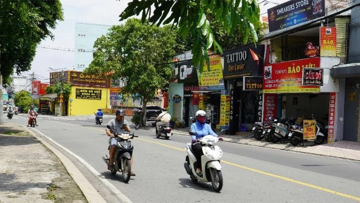 Người đàn ông chạy chậm sát lề đường để xem điện thoại - Ảnh: ĐỊNH DƯƠNG