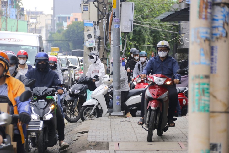 Vào khoảng 8h sáng hằng ngày, tình trạng kẹt xe thường xuyên diễn ra, nhiều người phải leo lề để vượt qua quãng kẹt - Ảnh: TIẾN QUỐC