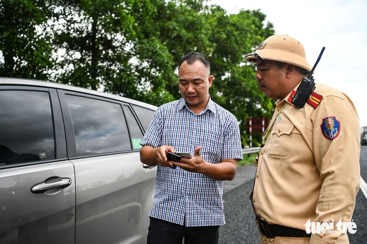 Ngoài ra, nhiều tài xế hiện chưa tích hợp giấy tờ trên VNeID cũng được cảnh sát khuyến khích, nhắc nhở đồng thời hướng dẫn họ thực hiện - Ảnh: HỒNG QUANG