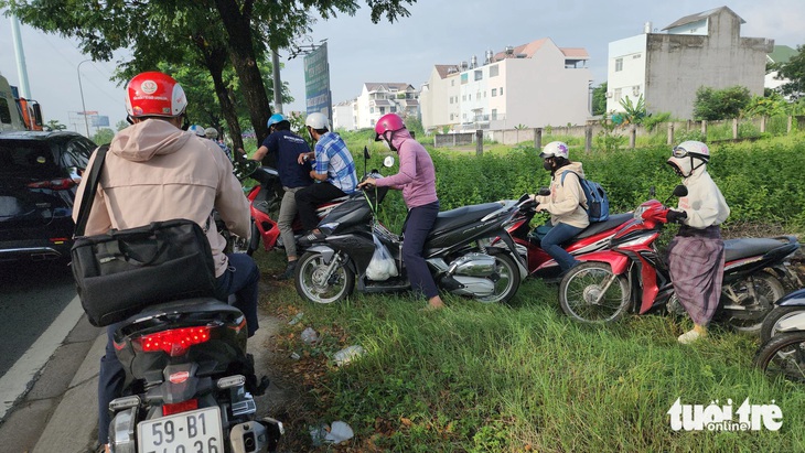 Kẹt xe trên đường Võ Chí Công, nhiều người leo vỉa hè, chạy vào bãi cỏ ven đường - Ảnh: MINH HÒA