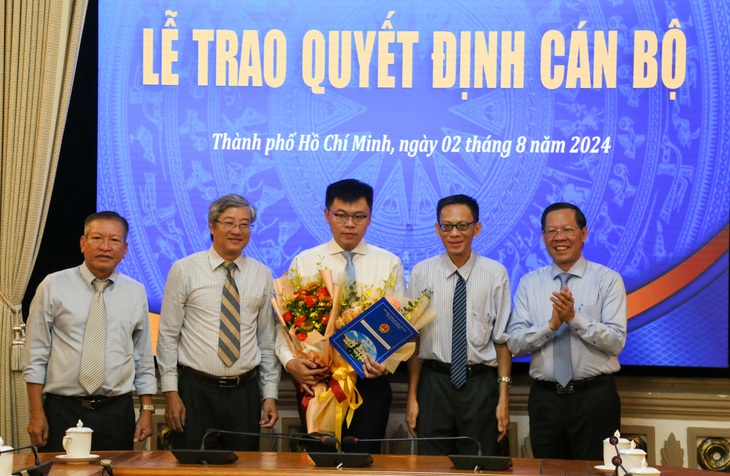 Lãnh đạo TP.HCM và Viện Nghiên cứu phát triển TP.HCM tặng hoa chúc mừng ông Trương Minh Huy Vũ - Ảnh: THẢO LÊ