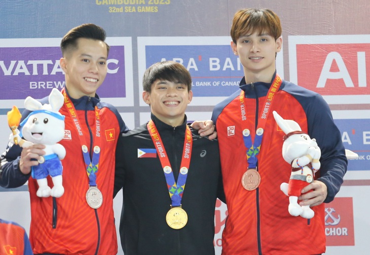 Carlos Yulo đứng cạnh Lê Thanh Tùng (trái) và Đinh Phương Thành (phải) ở SEA Games -  Ảnh: ĐỨC KHUÊ