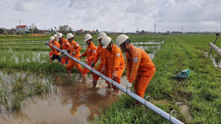 Một nhóm công nhân Điện lực miền Trung dựng lại một trụ điện ngã đổ sau bão năm 2022 - Ảnh: EVNCPC cung cấp