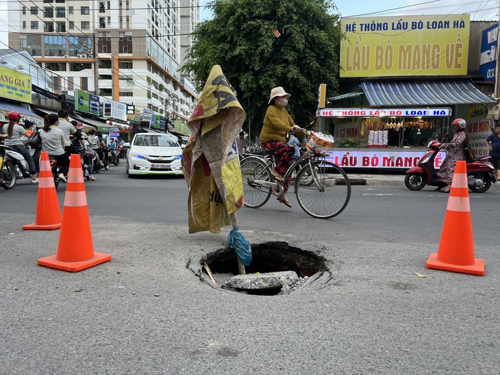 Một hố sâu xuất hiện sau cơn mưa trên đường An Bình, phường An Bình, TP Dĩ An, tỉnh Bình Dương từ chiều qua tới chiều nay vẫn còn - Ảnh: XUÂN ĐOÀN