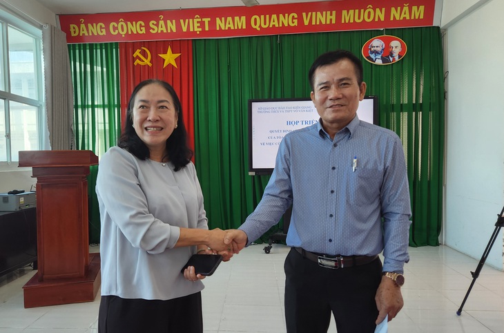 Bà Nguyễn Thị Minh Giang - nguyên giám đốc Sở Giáo dục và Đào tạo tỉnh Kiên Giang - bắt tay xin lỗi ông Nguyễn Đình Chung - nguyên hiệu trưởng Trường THCS - THPT Võ Văn Kiệt - Ảnh: BỬU ĐẤU