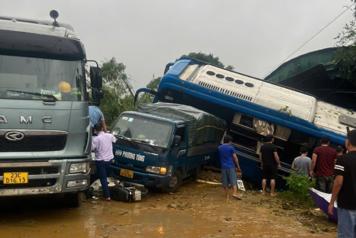 Sạt lở đè trúng nhiều xe cộ và nhà dân, 10 người bị thương, 2 người mất tích - Ảnh 1.