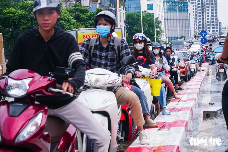 Hà Nội vẫn ngập khắp nơi, thợ sửa xe 'cắm chốt' ngay tại điểm ngập để sửa xe chết máy - Ảnh 4.