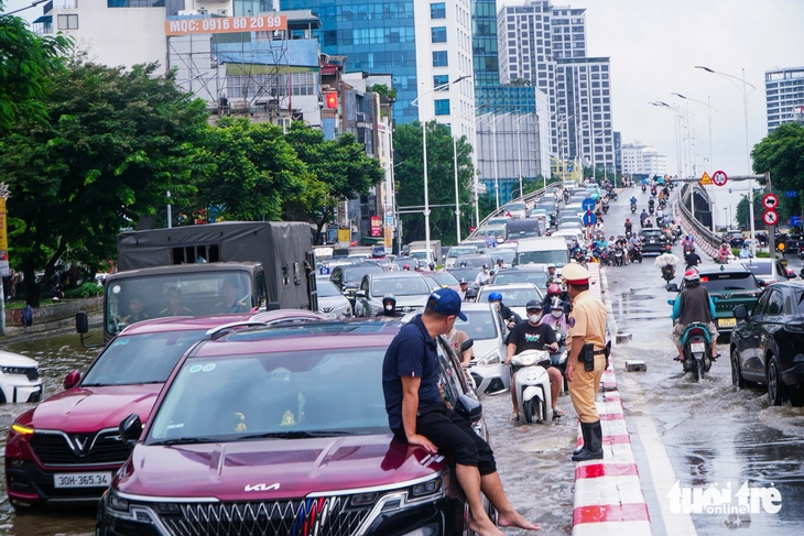 Hà Nội vẫn ngập khắp nơi, thợ sửa xe 'cắm chốt' ngay tại điểm ngập để sửa xe chết máy - Ảnh 5.