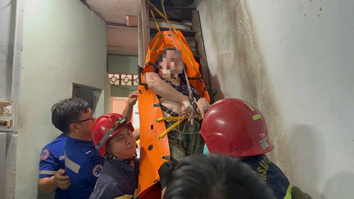 Cảnh sát chữa cháy TP.HCM giải cứu người phụ nữ hơn 100kg sốt cao trên gác xép - Ảnh 1.