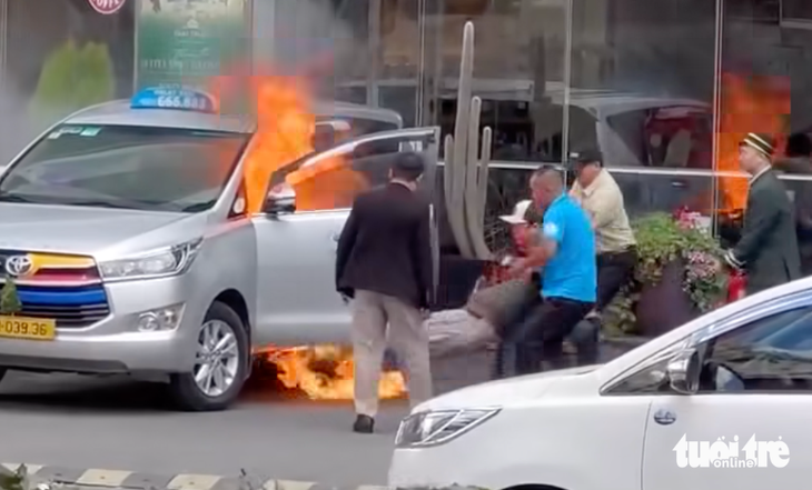 Bảo vệ khách sạn giải cứu tài xế kẹt trong taxi đang bốc cháy- Ảnh 1. Bảo vệ khách sạn giải cứu tài xế kẹt trong taxi đang bốc cháy - Ảnh 1.