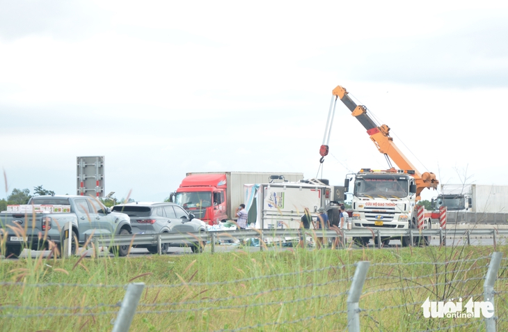 Xe tải lật chắn ngang cao tốc Vĩnh Hảo - Phan Thiết, nhiều tài xế cùng phụ dọn hàng hóa rơi vãi - Ảnh 1.