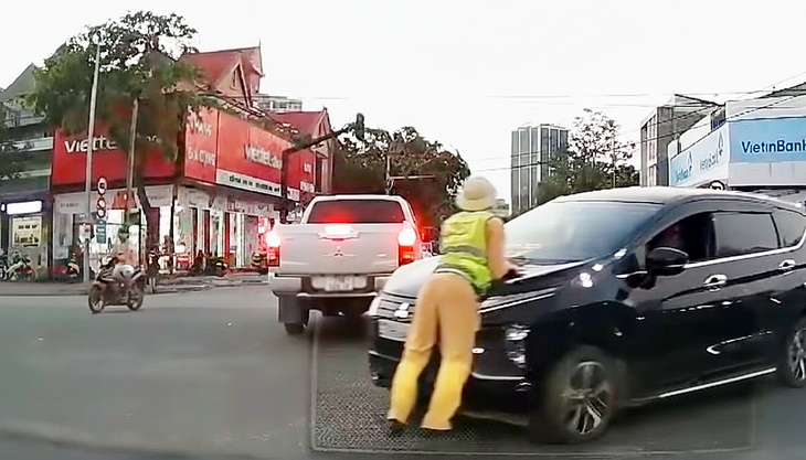 Thiếu tá cảnh sát giao thông bị hất lên nắp capô giờ tan tầm - Ảnh 1.