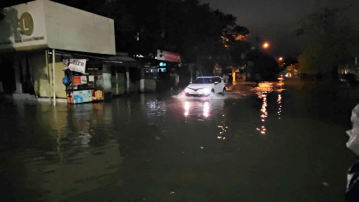Huế mưa lớn, nhiều nơi ngập sâu trong nước, cuốn trôi xe taxi - Ảnh 1.