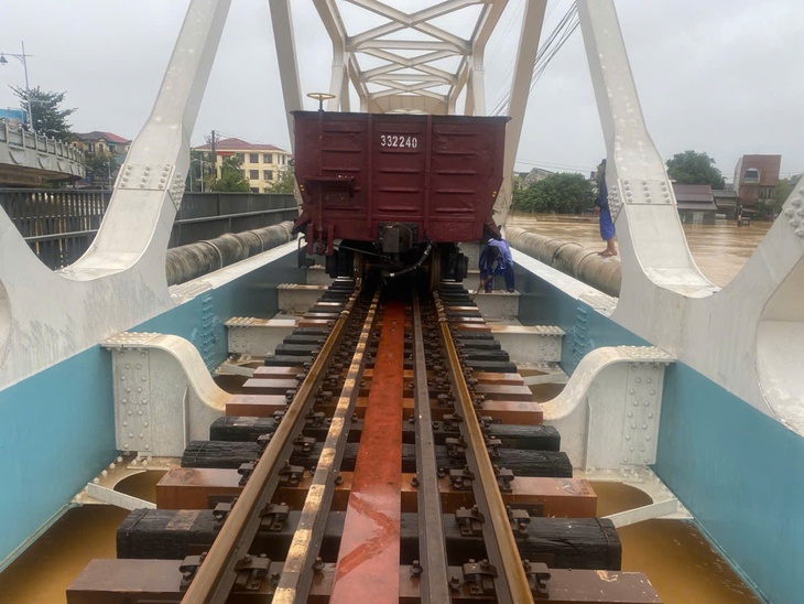 Nước lũ lại dâng, đưa 2 đoàn tàu chở đá 1.100 tấn chống trôi cầu đường sắt trăm tuổi - Ảnh 1.