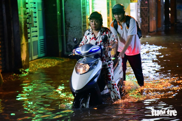 Người dân vẫn bì bõm trong dòng nước ngập dù mưa đã tạnh từ lâu - Ảnh 1.