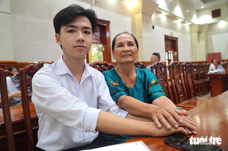 Bà nội nắm tay không rời đứa cháu bị cha mẹ bỏ lại đậu ĐH Kinh tế TP.HCM đi nhận học bổng - Ảnh 1.