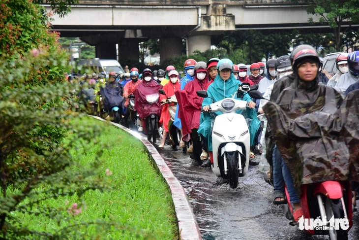Hàng ngàn người dân ở TP.HCM đội mưa, nhích từng chút đi học, đi làm - Ảnh 4.