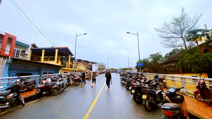 Người dân Huế đưa xe cộ lên cầu tránh lũ, công an khuyến cáo hành vi này nguy hiểm - Ảnh 2.