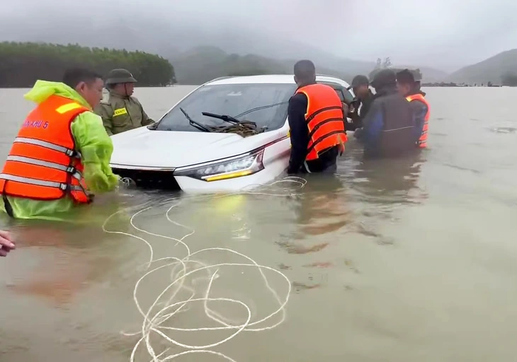 Ô tô chở 2 người bị nước lũ cuốn trôi, may mắn được cứu hộ kịp thời - Ảnh 1.