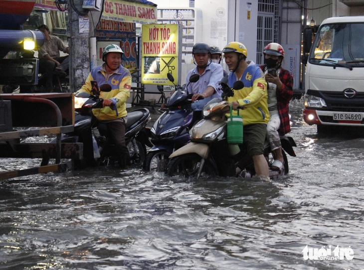 Người dân TP.HCM 'ướt nhẹp' giờ tan tầm dù trời không mưa - Ảnh 3.