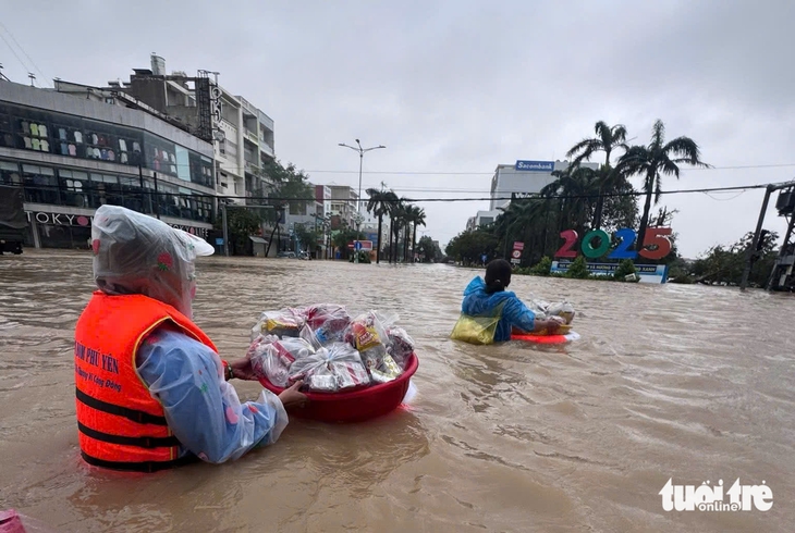 Chung tay góp từng chai nước, bánh chưng, cơm nóng vượt lũ đến những vùng ngập sâu - Ảnh 4.