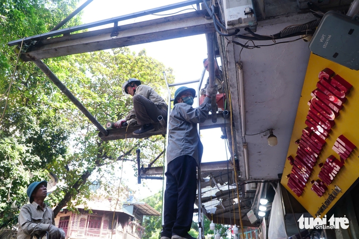 Hà Nội lại ra quân giành vỉa hè cho người đi bộ, tuyến phố Hàng Mã bị tháo hàng loạt mái che - Ảnh 1.