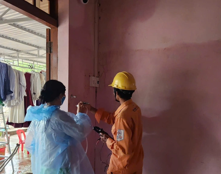 Công nhân điện lực lội nước rọi đèn pin xuyên đêm cấp điện trở lại cho 1,2 triệu khách hàng vùng lũ - Ảnh 7.