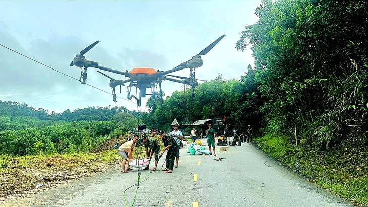 Huy động drone cẩu từng bao gạo 60kg bay đến vùng sạt lở - Ảnh 1.