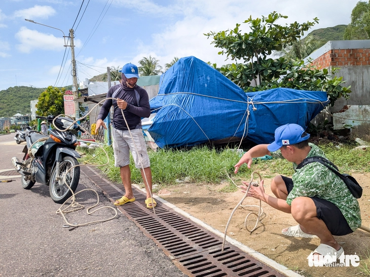 Người dân ven biển chèn bao nước, đá hộc lên mái nhà chống bão Kalmaegi - Ảnh 7.