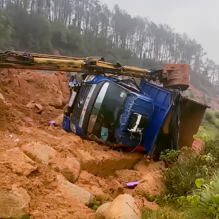 Sạt lở núi xô nghiêng máy múc và xe tải, hai công nhân bị thương - Ảnh 1.