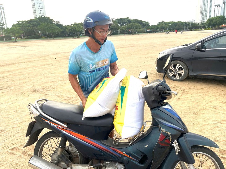 Dân Nha Trang ùn ùn ra biển xúc cát về nhà chống bão Kalmaegi- Ảnh 1. Dân Nha Trang ùn ùn ra biển xúc cát về nhà chống bão Kalmaegi - Ảnh 1.