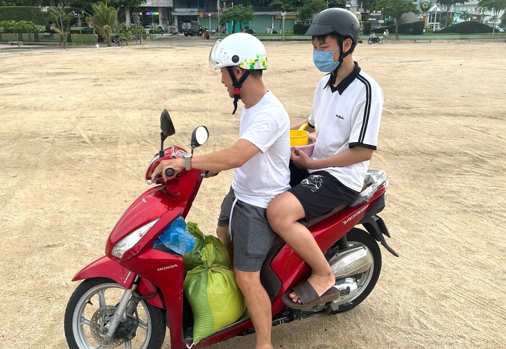 Dân Nha Trang ùn ùn ra biển xúc cát về nhà chống bão Kalmaegi- Ảnh 2. Dân Nha Trang ùn ùn ra biển xúc cát về nhà chống bão Kalmaegi- Ảnh 2.