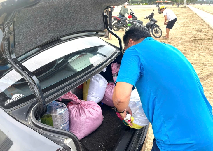 Dân Nha Trang ùn ùn ra biển xúc cát về nhà chống bão Kalmaegi- Ảnh 3. Dân Nha Trang ùn ùn ra biển xúc cát về nhà chống bão Kalmaegi- Ảnh 3.