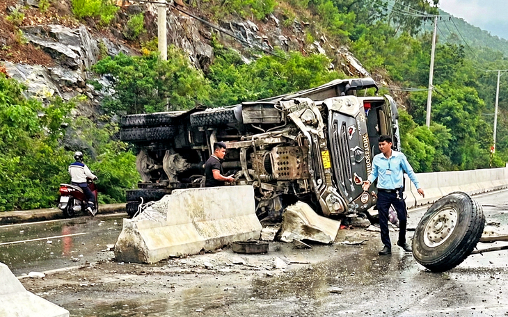 Xe tải lật chắn ngang, hàng chục bao thức ăn thủy sản tràn xuống đường - Ảnh 3.