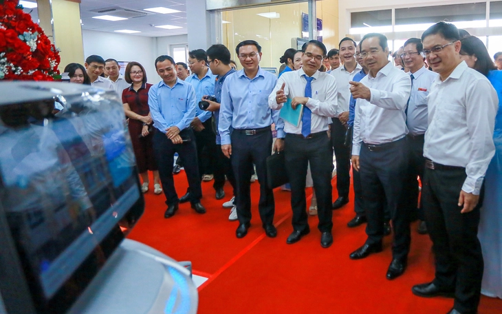 Đi làm thủ tục hành chính ở TP.HCM, người dân được robot bắt tay, mời ăn bánh - Ảnh 2.