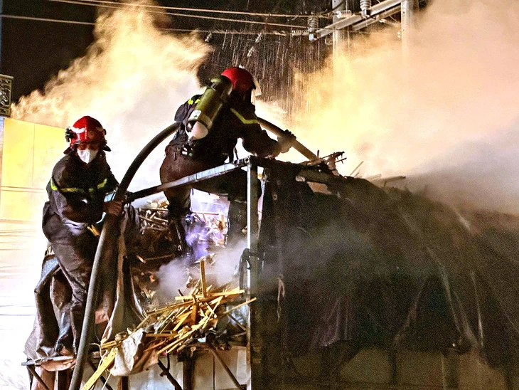 Xe tải chở gỗ bốc cháy, cảnh sát đeo mặt nạ chống độc để dập lửa - Ảnh 1.