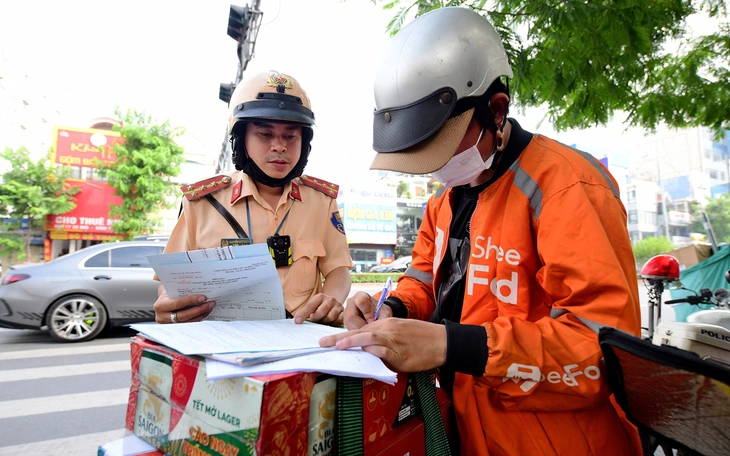 Vừa lái xe máy vừa cầm dù bị phạt đến 1 triệu đồng, trừ 4 điểm giấy phép lái xe - Ảnh 4.