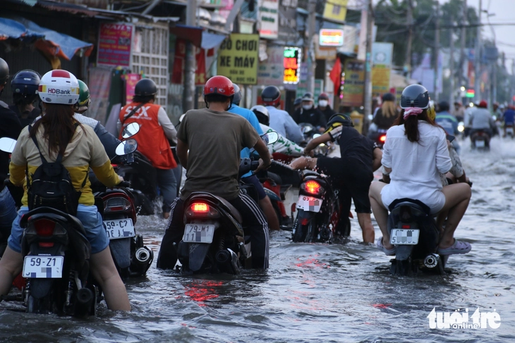 Người dân TP.HCM ngao ngán 'vượt' triều cường đầu tháng 2 Âm lịch - Ảnh 2.