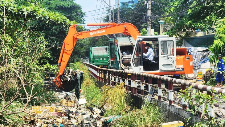 Huy động xe cuốc, xe ép rác dọn rác dồn ứ trên kênh ở quận Bình Tân sau phản ánh của Tuổi Trẻ - Ảnh 1.