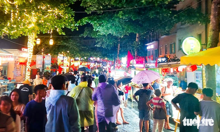 Du khách che dù, mặc áo mưa đi chơi lễ 30-4 ở Phú Quốc - Ảnh 2.