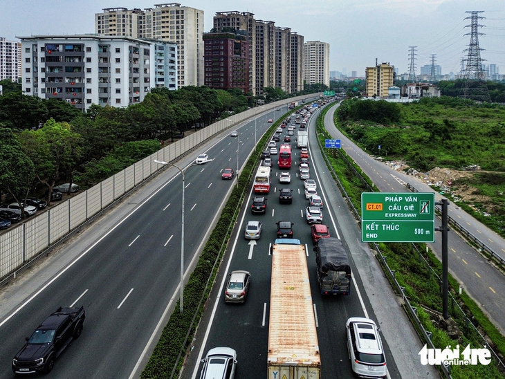 Người dân đội mưa trở lại Hà Nội sau kỳ nghỉ lễ - Ảnh 2.