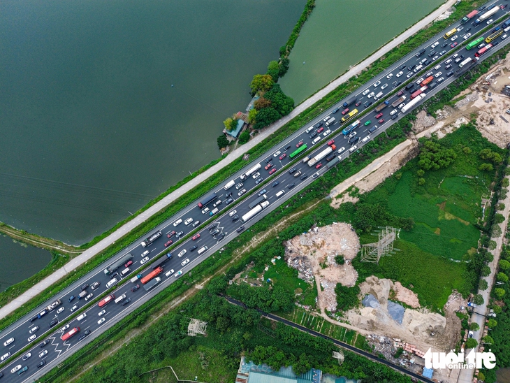 Người dân đội mưa trở lại Hà Nội sau kỳ nghỉ lễ - Ảnh 4.