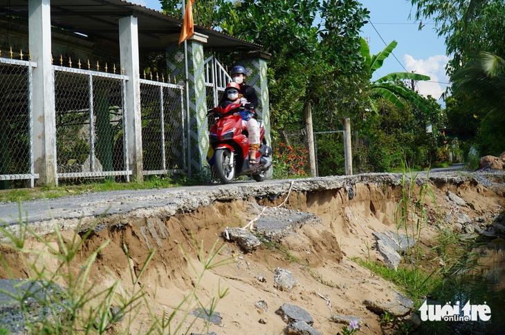 Đường dọc bờ sông sạt lở hơn một nửa, người dân vẫn bất chấp nguy hiểm để qua lại - Ảnh 2.