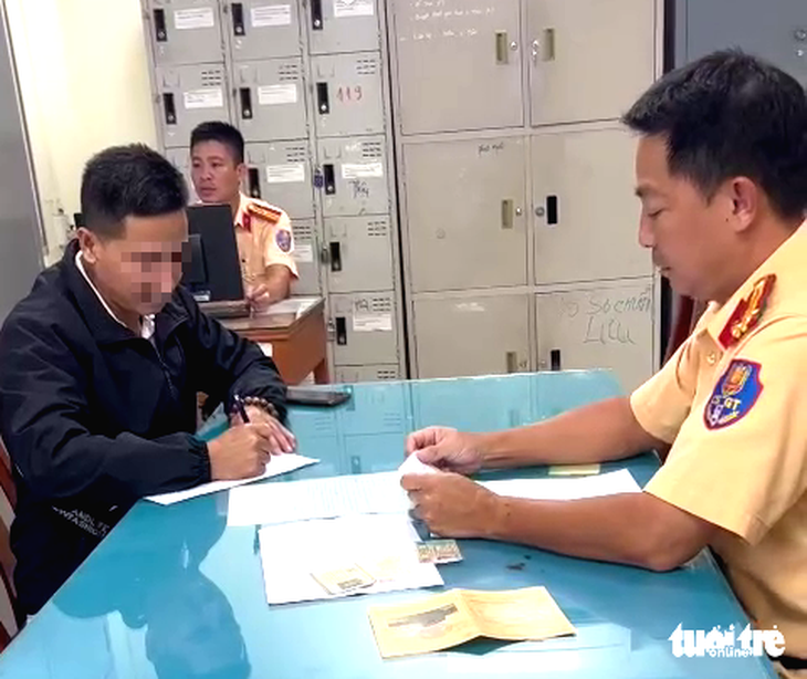 Tài xế xe khách lấn làn xe máy khi các xe khác đang dừng chờ đèn đỏ - Ảnh 1.