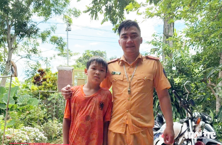 Thượng úy giao thông cứu bé trai giữa dòng nước lũ - Ảnh 1.