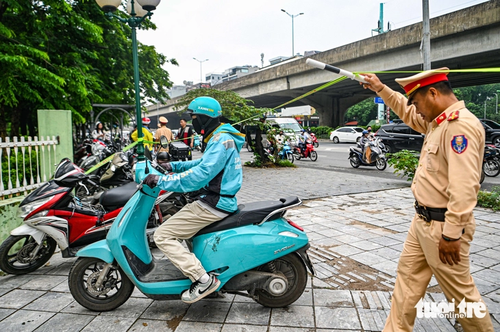 Một góc phố phạt hàng chục xe máy leo vỉa hè, xe ôm công nghệ cũng không 'thoát' - Ảnh 9.